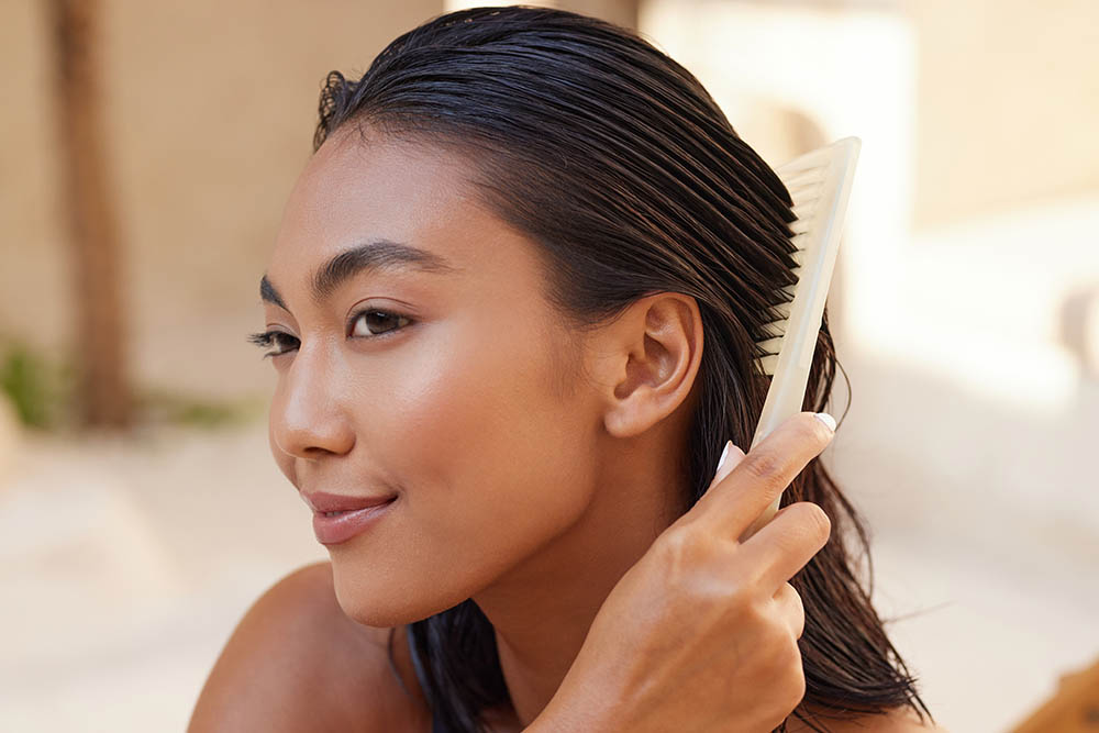 Hair Care Routine. Woman Combing Wet Hair With A Brush, Emphasizing Smooth And Shiny